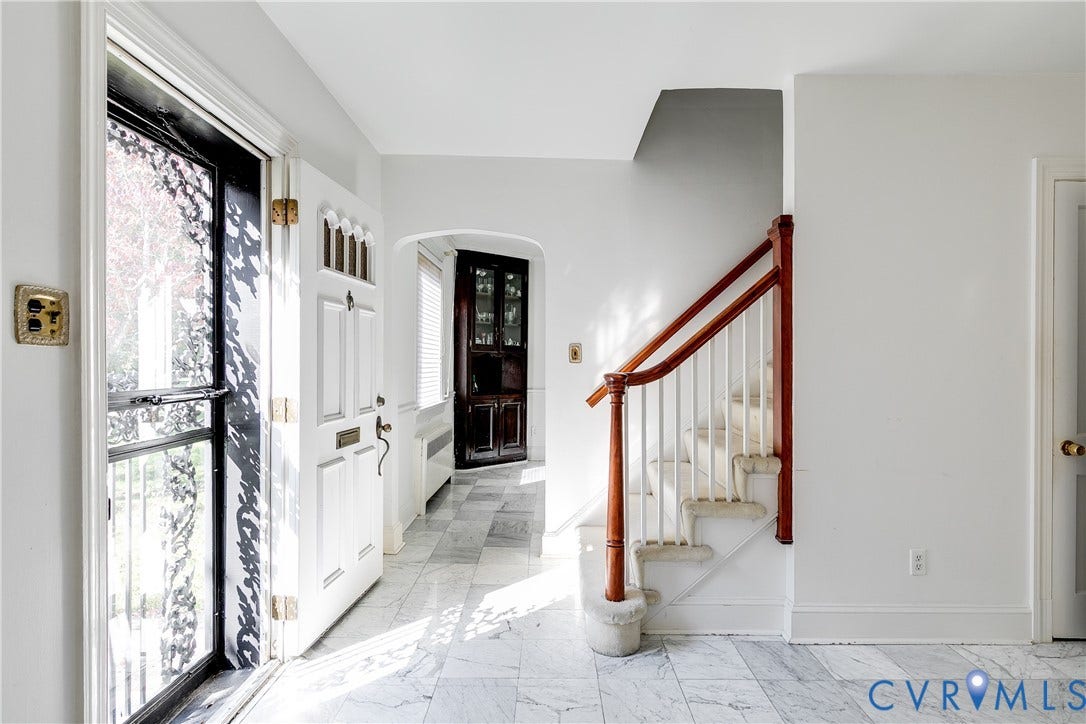 1406 Wentbridge Road, Richmond, VA 23227 Entryway featuring stone tile flooring, a multi-paneled front door with transom detailing, a staircase with a natural wood handrail, and built-in corner cabinetry