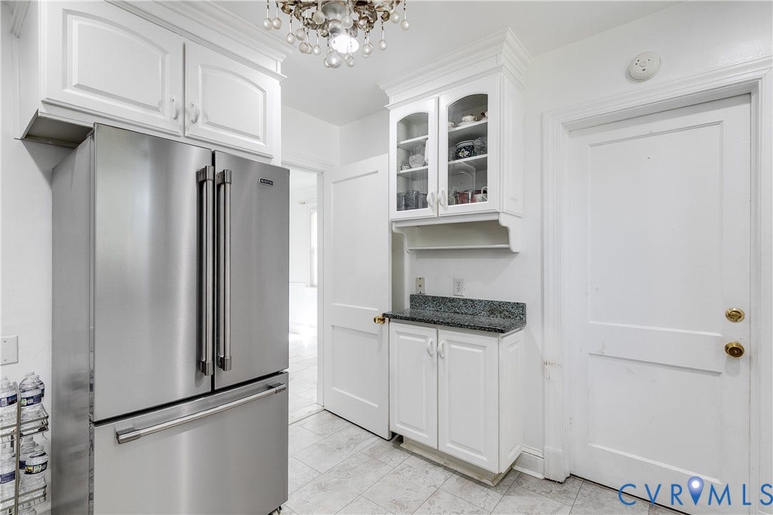 1406 Wentbridge Road, Richmond, VA 23227 Kitchen featuring white shaker-style cabinetry, glass-front upper cabinet doors, stone-surface countertop, stainless steel refrigerator, and tiled flooring