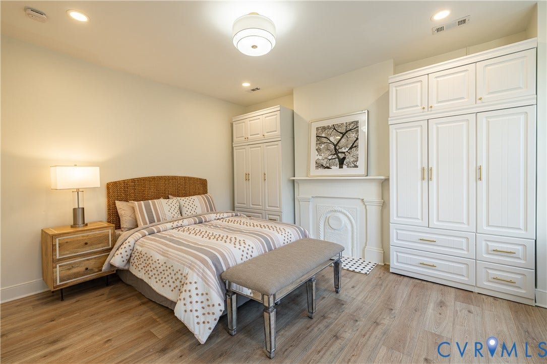 1108 W Marshall Street, Richmond, VA 23220 Room featuring wood-finish flooring, built-in white cabinetry, and a decorative fireplace surround