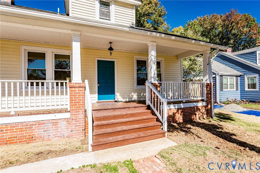 710 La Von Drive, Henrico, VA 23227 Covered front porch featuring brick-based columns, wood-finish stairs, white railings, and a solid-color front door
