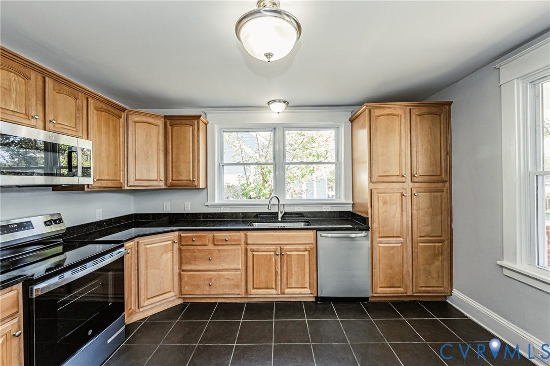 710 La Von Drive, Henrico, VA 23227 Kitchen featuring warm-toned cabinetry, dark stone countertops, stainless steel appliances, a central window above the sink, and tile flooring