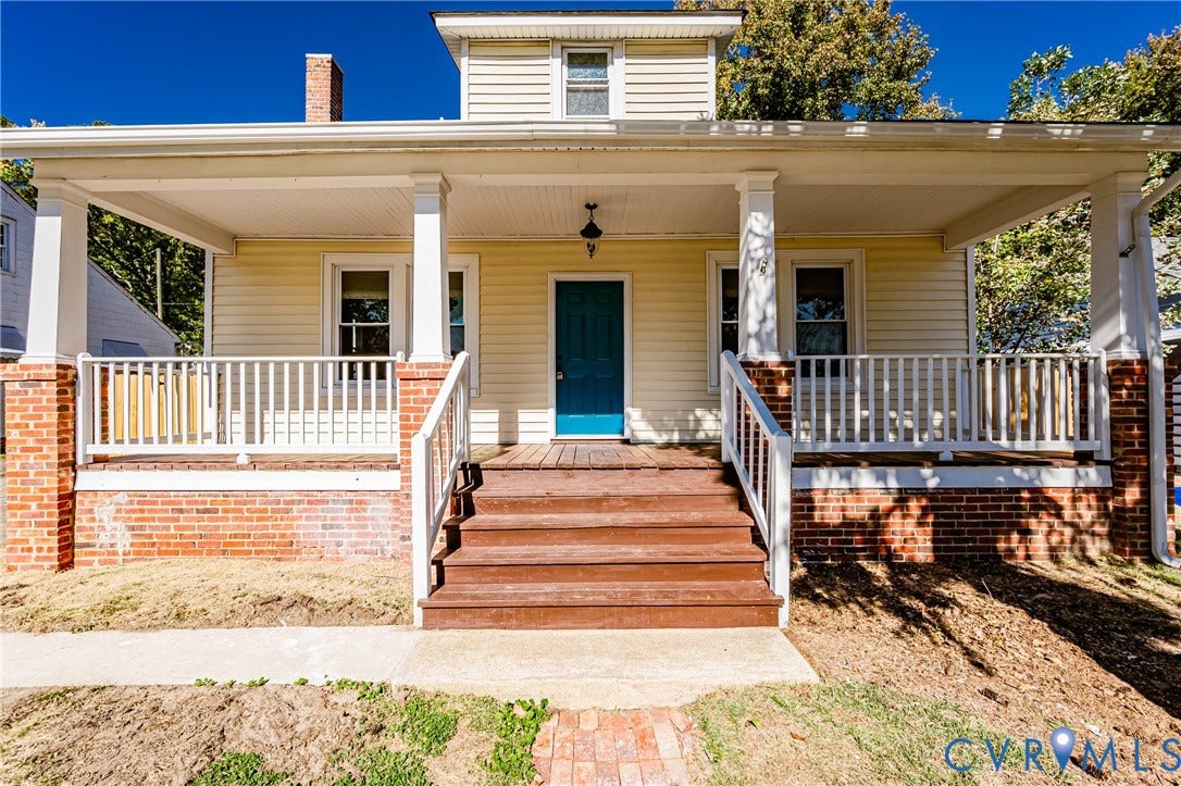 710 La Von Drive, Henrico, VA 23227 Covered front porch featuring brick-base columns, white wood railings, a central wooden staircase, and a masonry chimney
