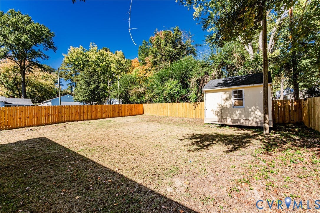710 La Von Drive, Henrico, VA 23227 Expansive backyard featuring a wood privacy fence, detached storage shed, and mature trees