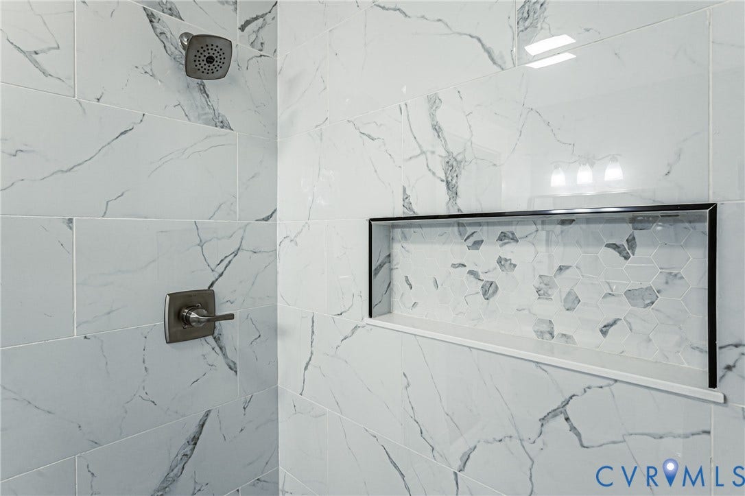 710 La Von Drive, Henrico, VA 23227 Large-format wall tiling with a vein-pattern finish, built-in recessed wall niche with hexagonal accent tile, and brushed nickel shower fixtures