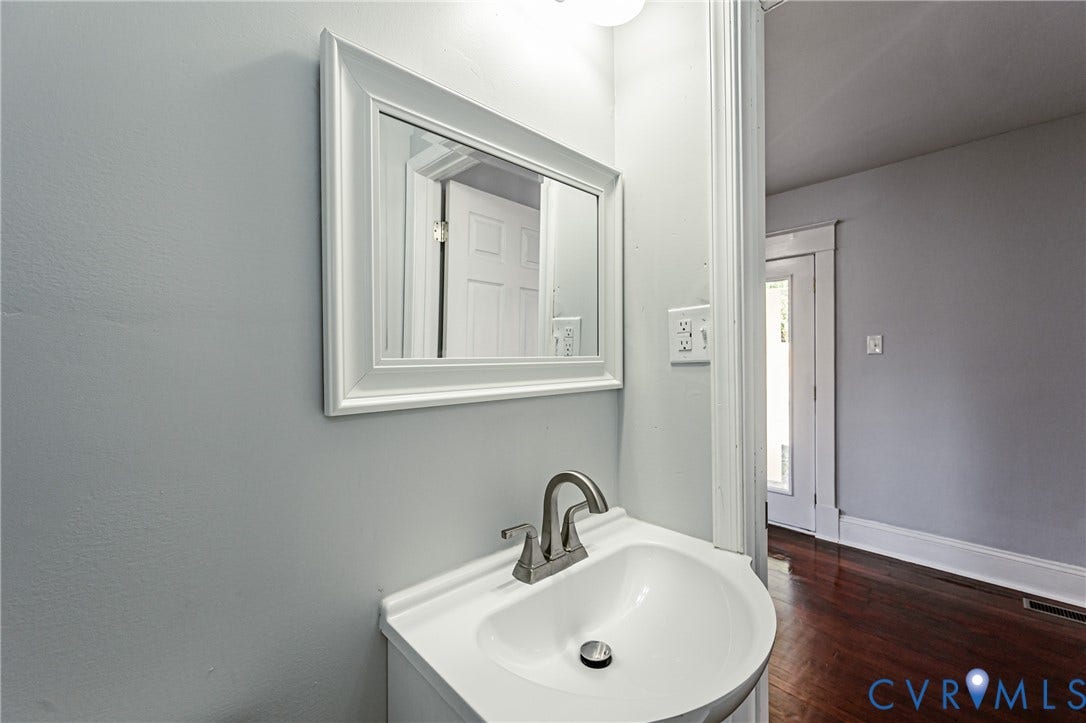 710 La Von Drive, Henrico, VA 23227 Wall-mounted vanity featuring a white basin, metallic faucet, and framed mirror with integrated lighting