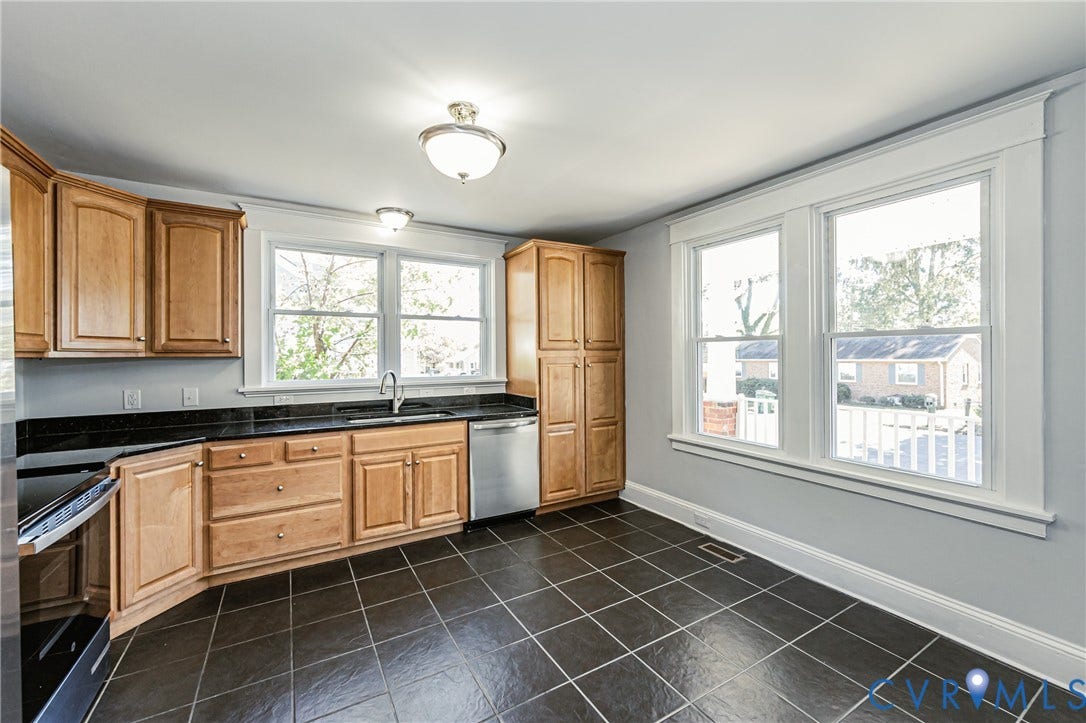 710 La Von Drive, Henrico, VA 23227 Kitchen featuring natural wood cabinetry, dark stone countertops, stainless steel appliances, large-format tile flooring, and dual multi-pane windows