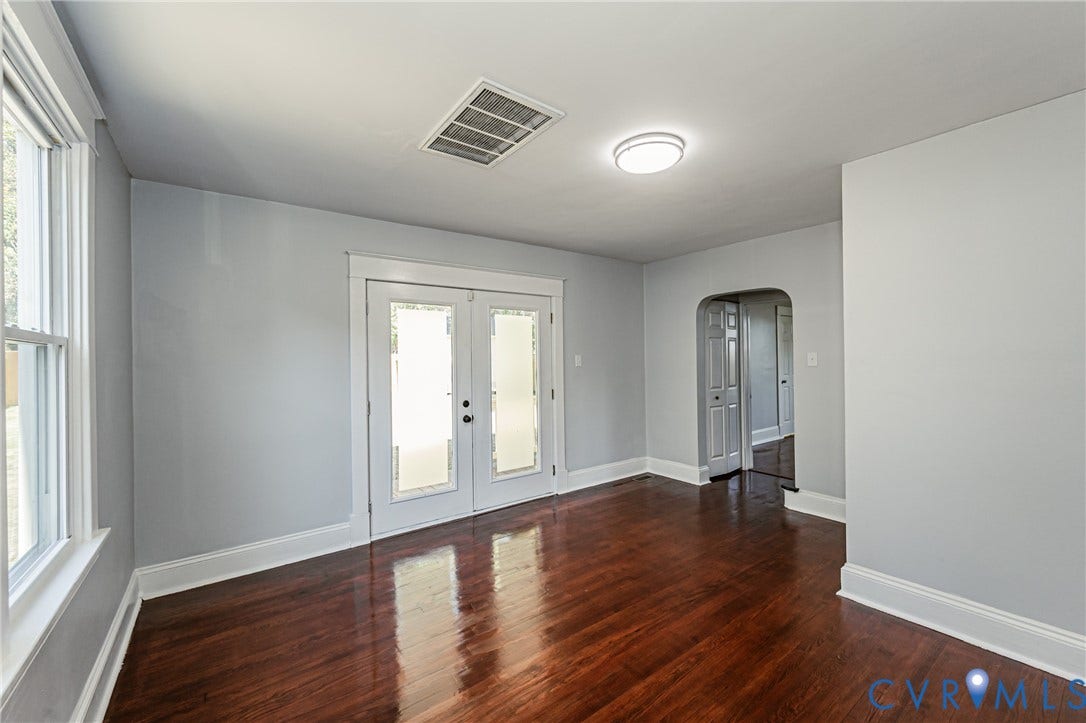 710 La Von Drive, Henrico, VA 23227 Interior space featuring wood-finish flooring, glass-panel French doors, an arched doorway, and a flush-mount ceiling light fixture