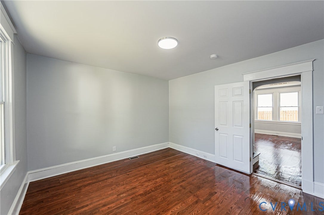 710 La Von Drive, Henrico, VA 23227 Interior room featuring wood-finish flooring, white six-panel door, neutral wall paint, and traditional door casing