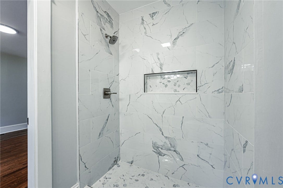710 La Von Drive, Henrico, VA 23227 Walk-in shower featuring large-format stone-patterned tile, integrated recessed shelving, and a metal rainfall showerhead with a matching wall-mounted control valve