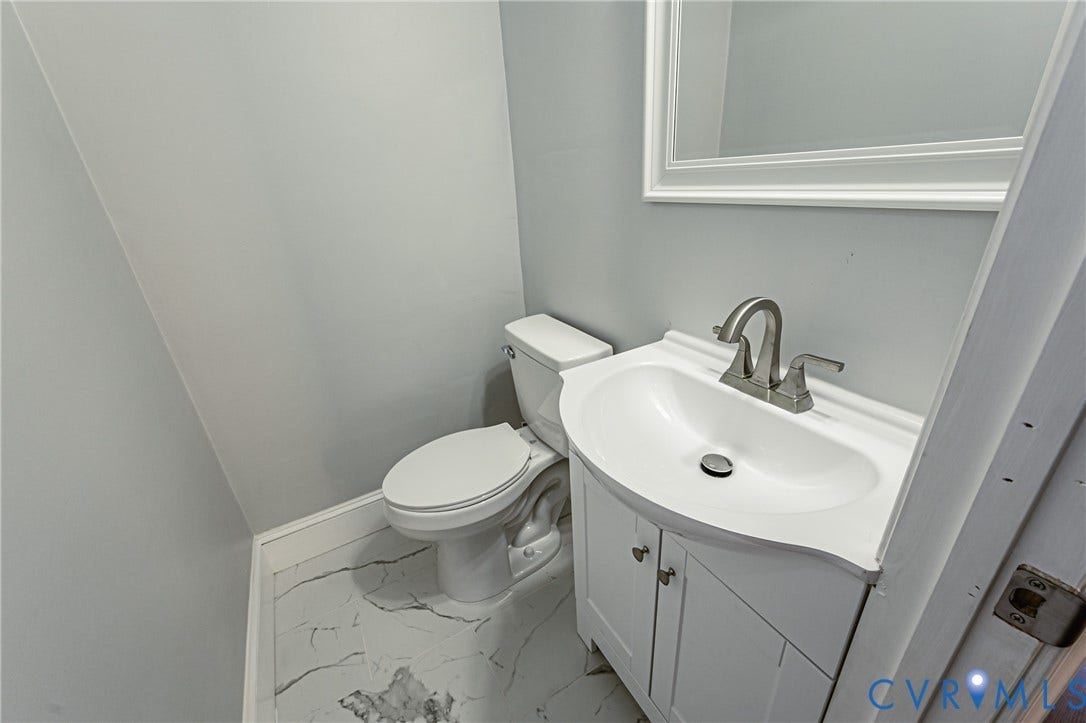 710 La Von Drive, Henrico, VA 23227 Bathroom featuring a white vanity cabinet with an integrated sink, brushed nickel faucet, wall-mounted mirror, and tile flooring