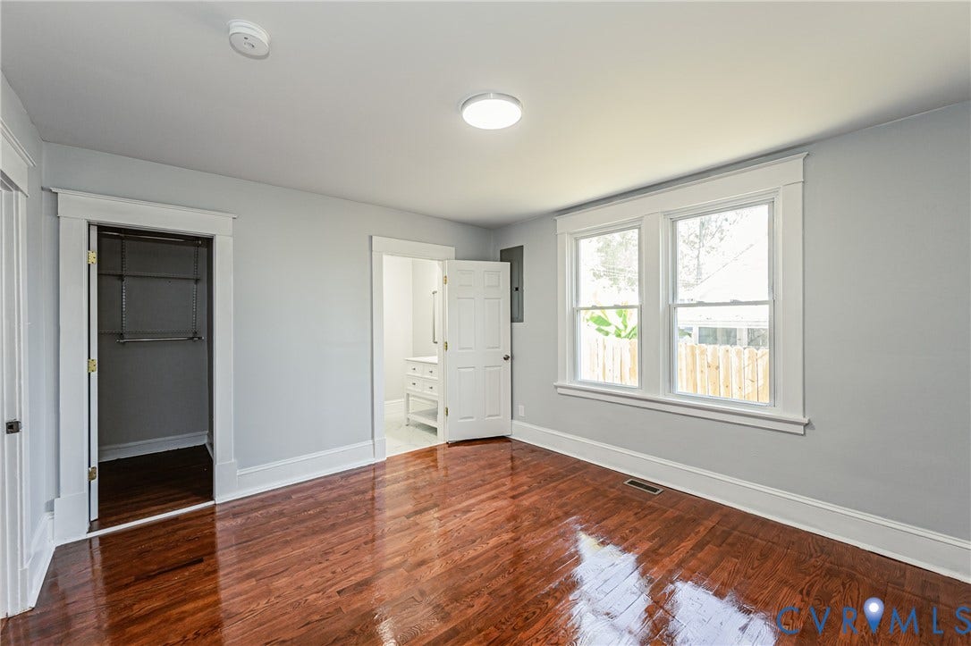 710 La Von Drive, Henrico, VA 23227 Room featuring polished wood-finish flooring, white door and window casing, dual-pane windows, and a walk-in closet