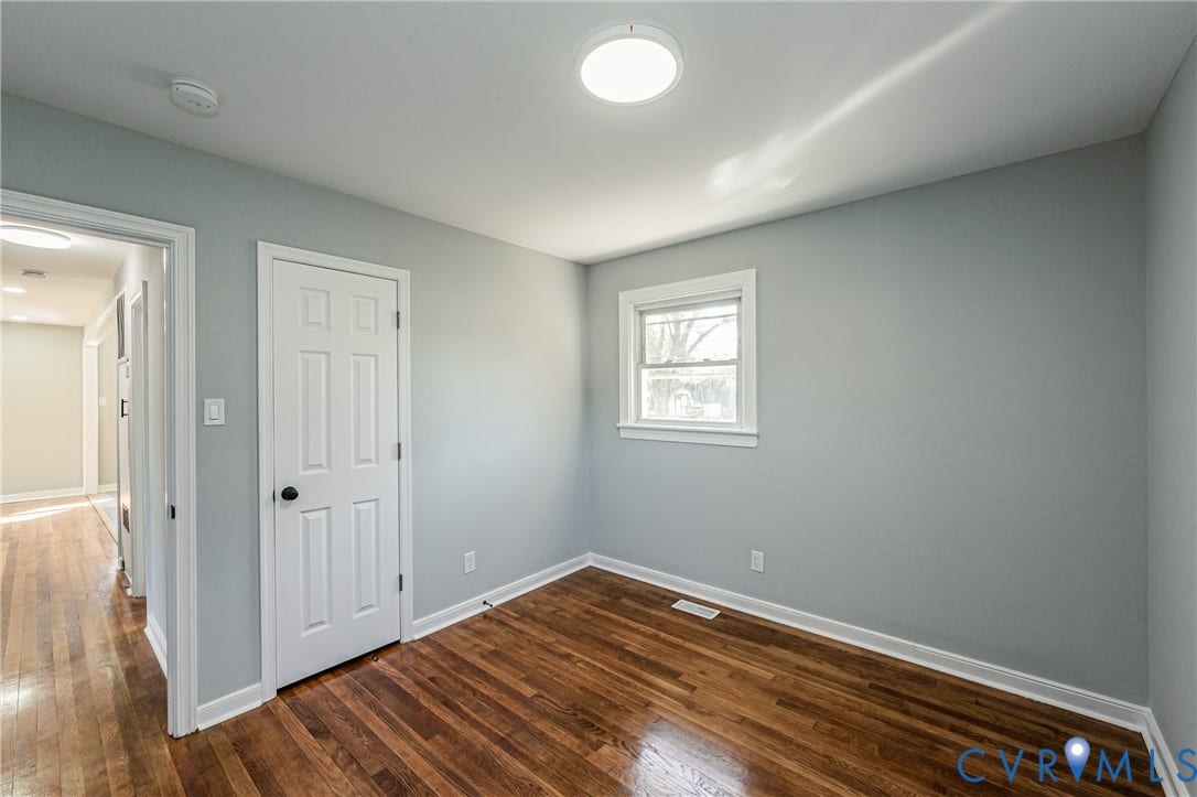 506 Meadowspring Road, Henrico, VA 23223 Neutral-toned interior space featuring wood-finish flooring, a single-panel window, a white six-panel door, and a flush-mount overhead light fixture