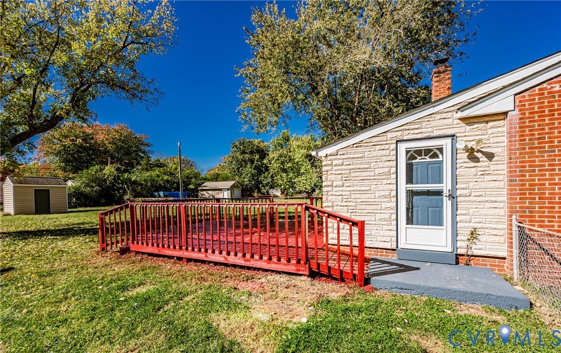 506 Meadowspring Road, Henrico, VA 23223 Exterior features include a red-painted wood deck, brick and stone masonry siding, a single-story storage shed, and a fenced yard