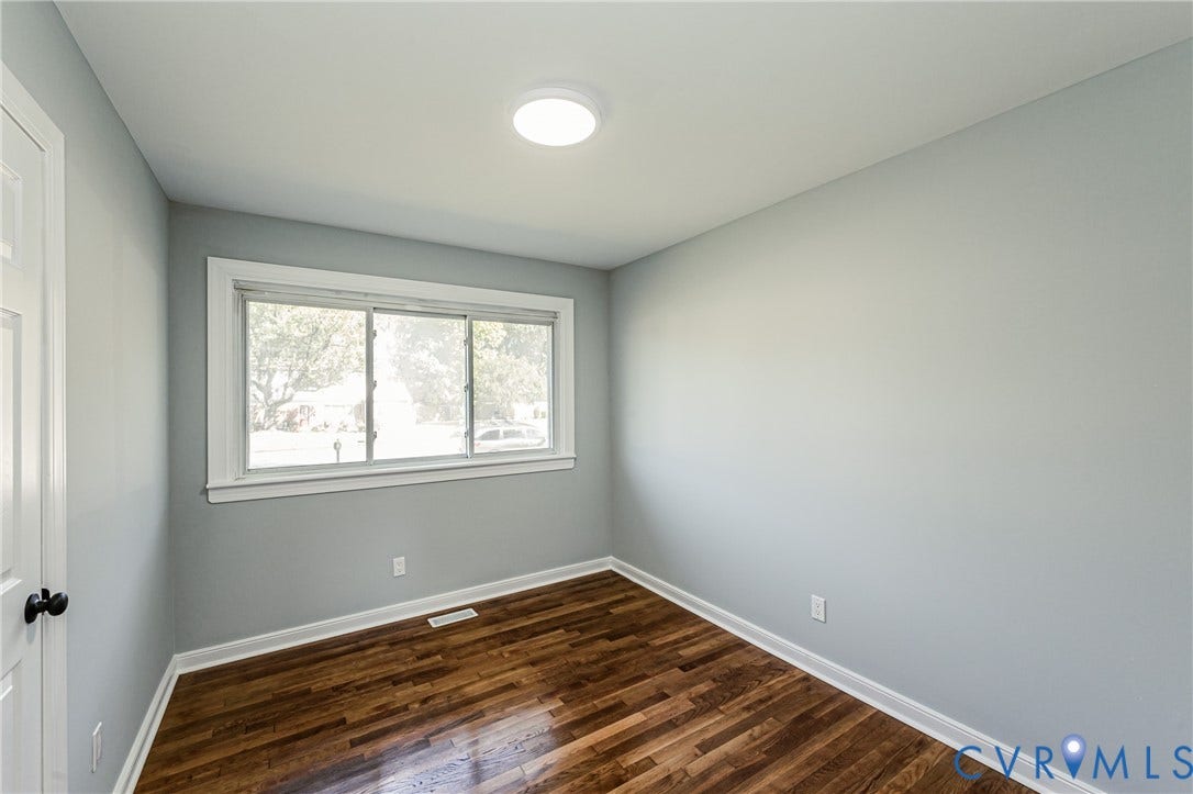 506 Meadowspring Road, Henrico, VA 23223 Interior space featuring wood-finish flooring, neutral wall tones, a large slider window, and a flush-mount ceiling light fixture