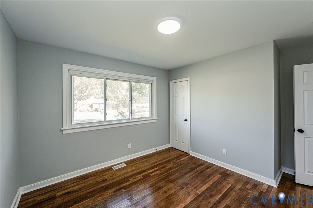 506 Meadowspring Road, Henrico, VA 23223 Neutral-toned interior featuring wood-finish flooring, a large window with white trim, and two paneled interior doors