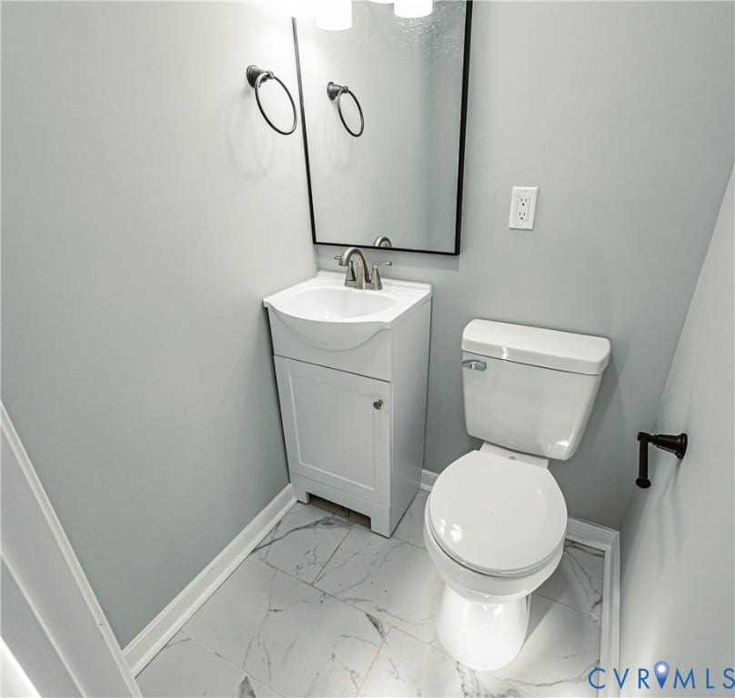 506 Meadowspring Road, Henrico, VA 23223 Compact vanity with a white integrated sink, polished metal faucet, wall-mounted rectangular mirror, and large-format tile flooring