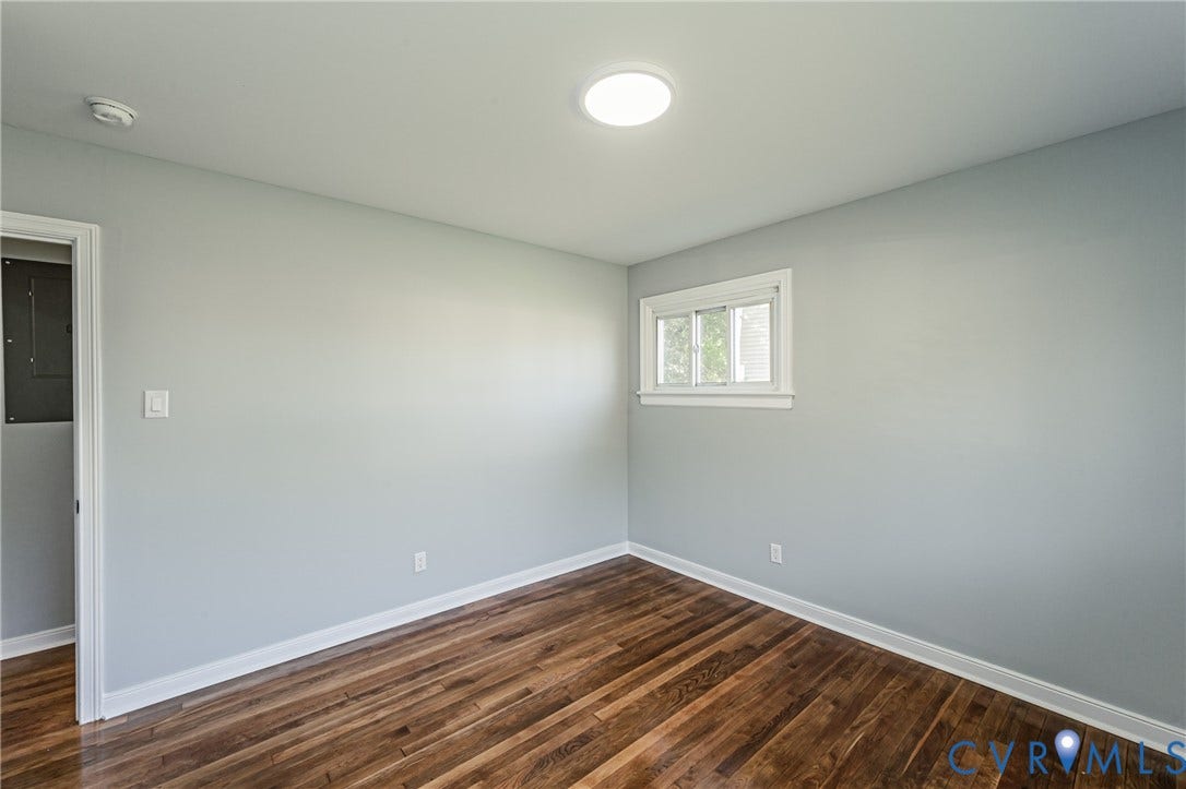 506 Meadowspring Road, Henrico, VA 23223 Room interior featuring wood-finish flooring, neutral wall paint, and a white-trimmed sliding window