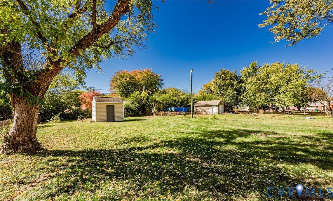 506 Meadowspring Road, Henrico, VA 23223 Expansive yard featuring mature trees, a detached storage structure, and a fenced perimeter