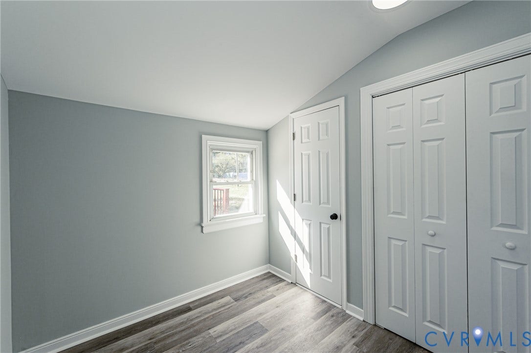 506 Meadowspring Road, Henrico, VA 23223 Room featuring wood-finish flooring, a single window, a six-panel interior door, and a built-in closet with bifold doors