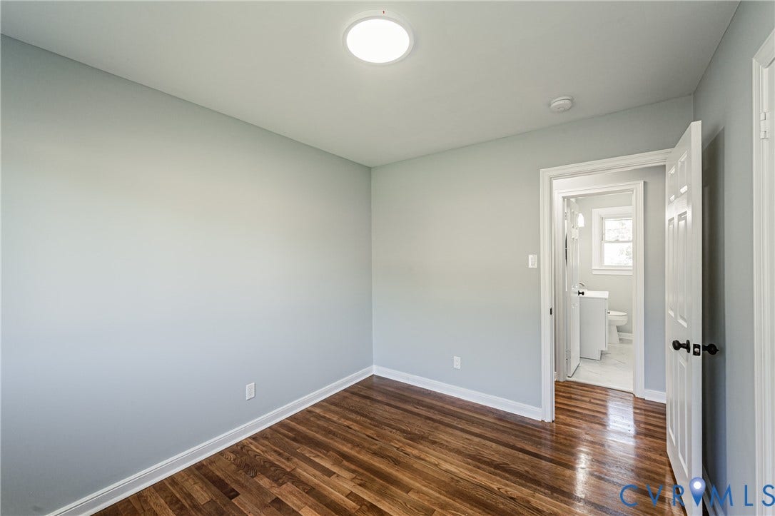 506 Meadowspring Road, Henrico, VA 23223 Room featuring light-toned neutral walls, polished wood-finish flooring, and a flush-mount ceiling light fixture