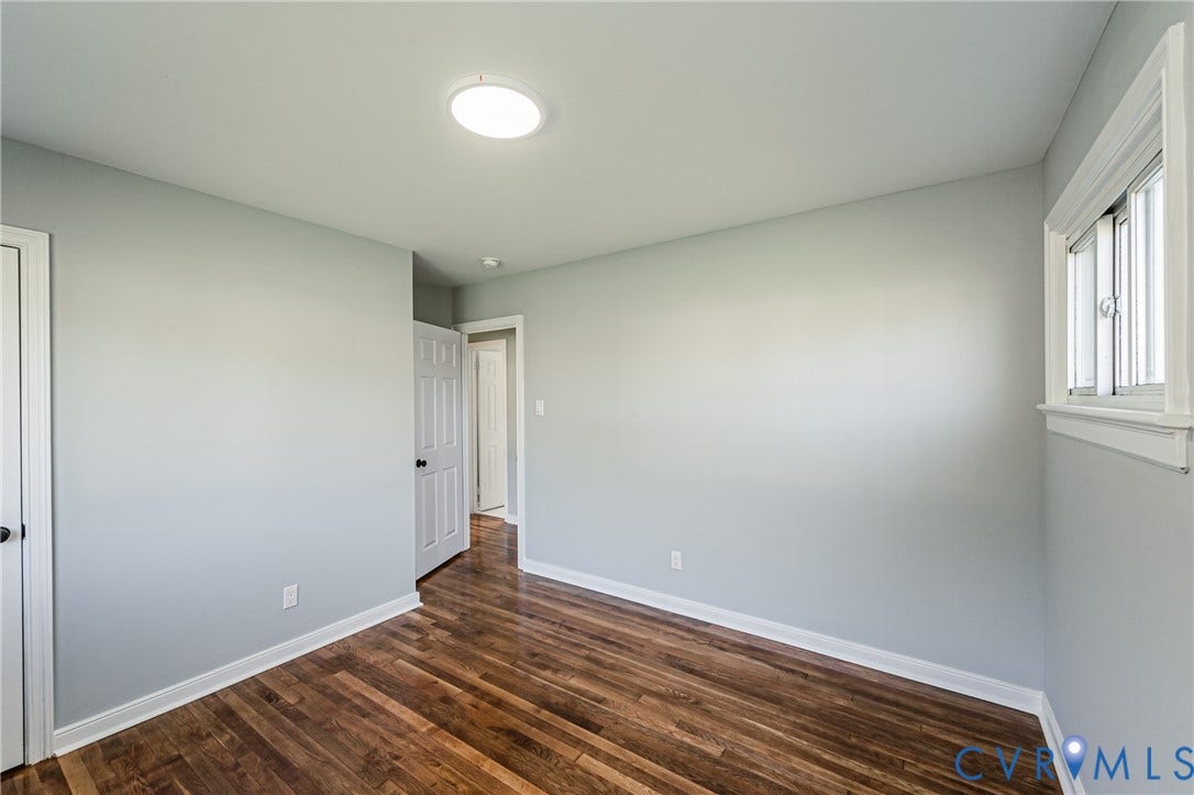 506 Meadowspring Road, Henrico, VA 23223 Interior room featuring wood-finish flooring, light gray walls, a sliding window with white casing, and a flush-mount light fixture
