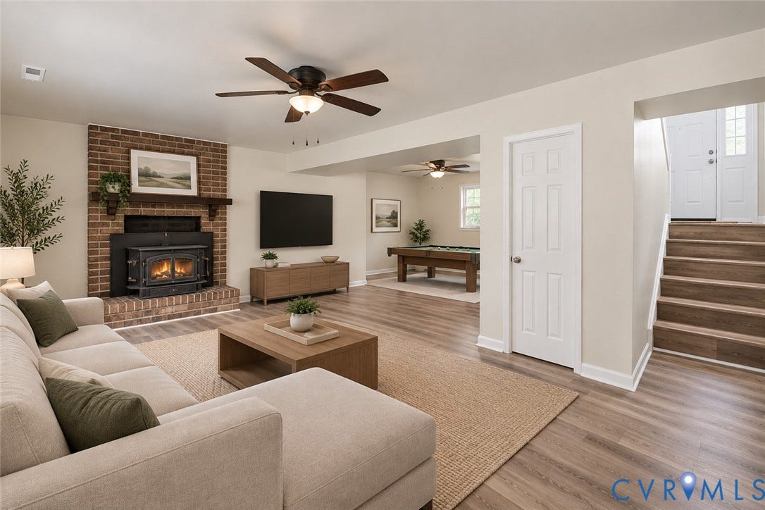 9737 Graves Road, South Chesterfield, VA 23803 Living area featuring a full-height brick fireplace with a wood-mantel insert, wood-finish flooring, and ceiling fans, ai staged