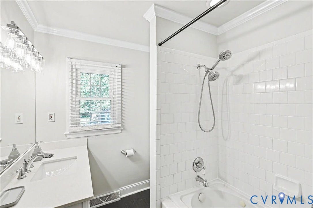 9737 Graves Road, South Chesterfield, VA 23803 Bathroom featuring a white vanity with a rectangular sink, multi-light fixture, tiled tub-shower surround, and a handheld shower head