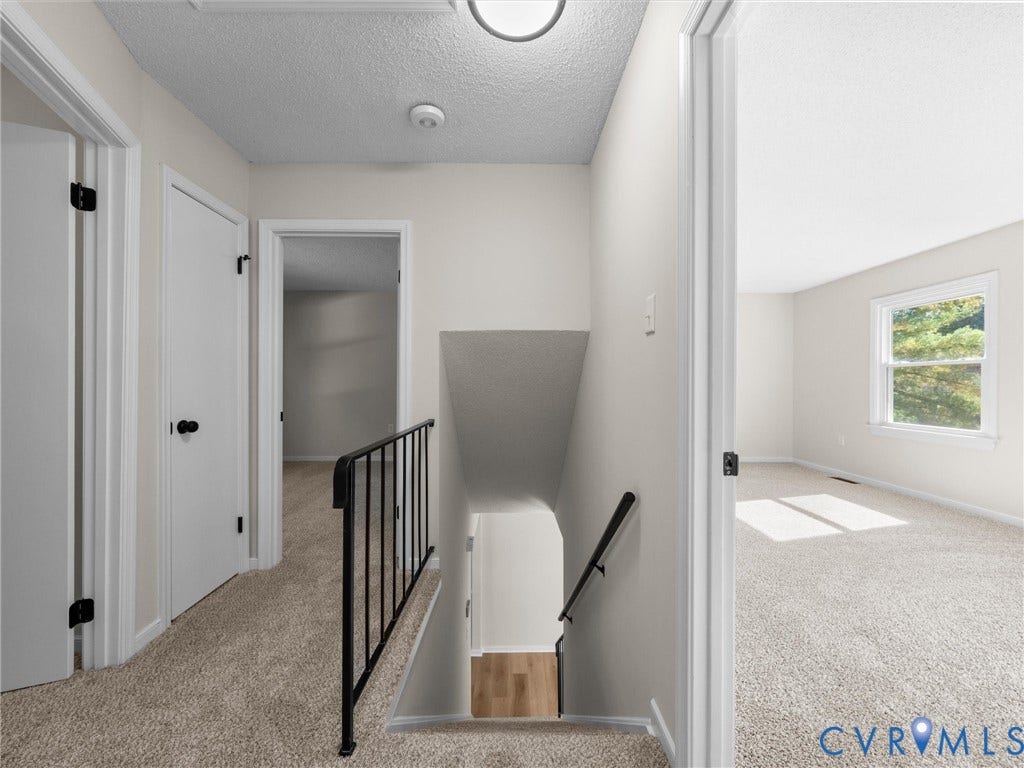 406 Alamosa Drive, Henrico, VA 23075 Neutral-toned interior featuring wall-to-wall carpeting, metal stair railing with a coordinating handrail, and multiple interior passage doors