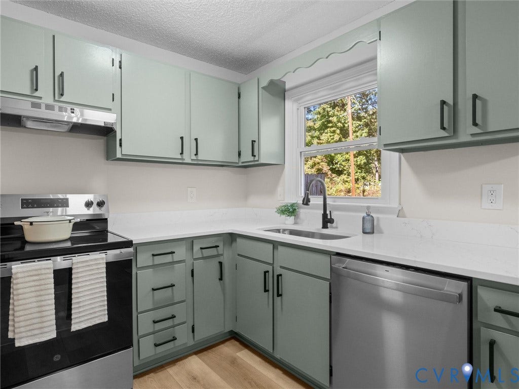 406 Alamosa Drive, Henrico, VA 23075 Kitchen featuring sage green shaker-style cabinetry, matte black hardware, white solid-surface countertops, stainless steel appliances, and wood-finish flooring