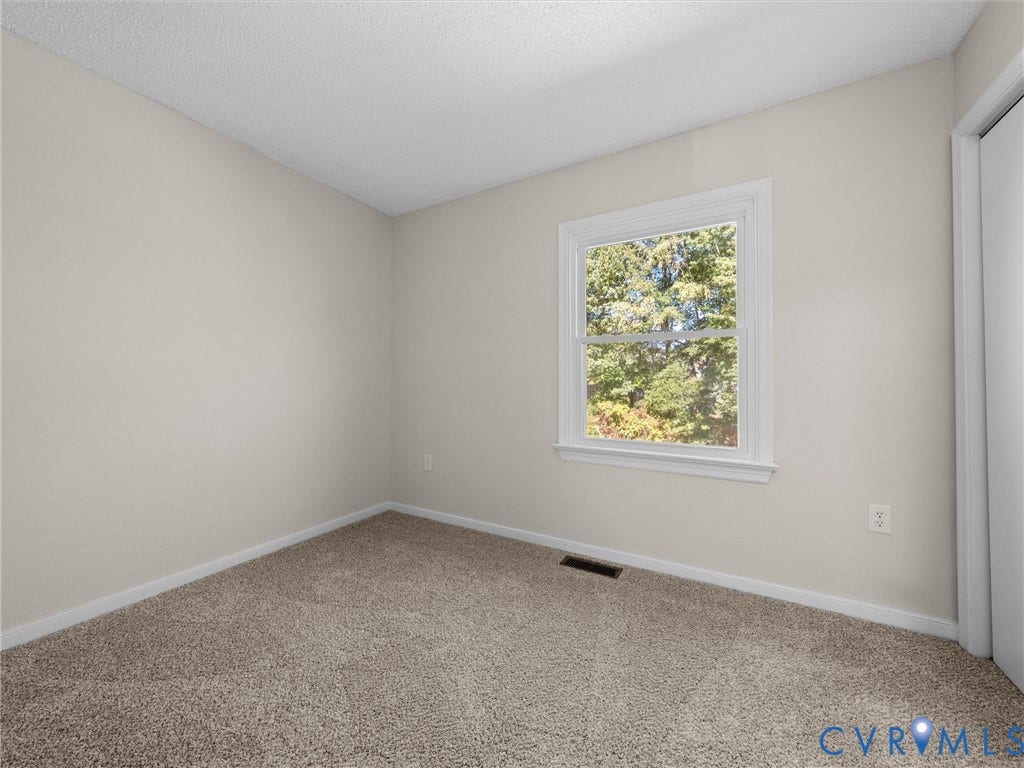 406 Alamosa Drive, Henrico, VA 23075 Neutral-toned interior space featuring wall-to-wall carpeting, a single-pane window with white casing, and a sliding closet door