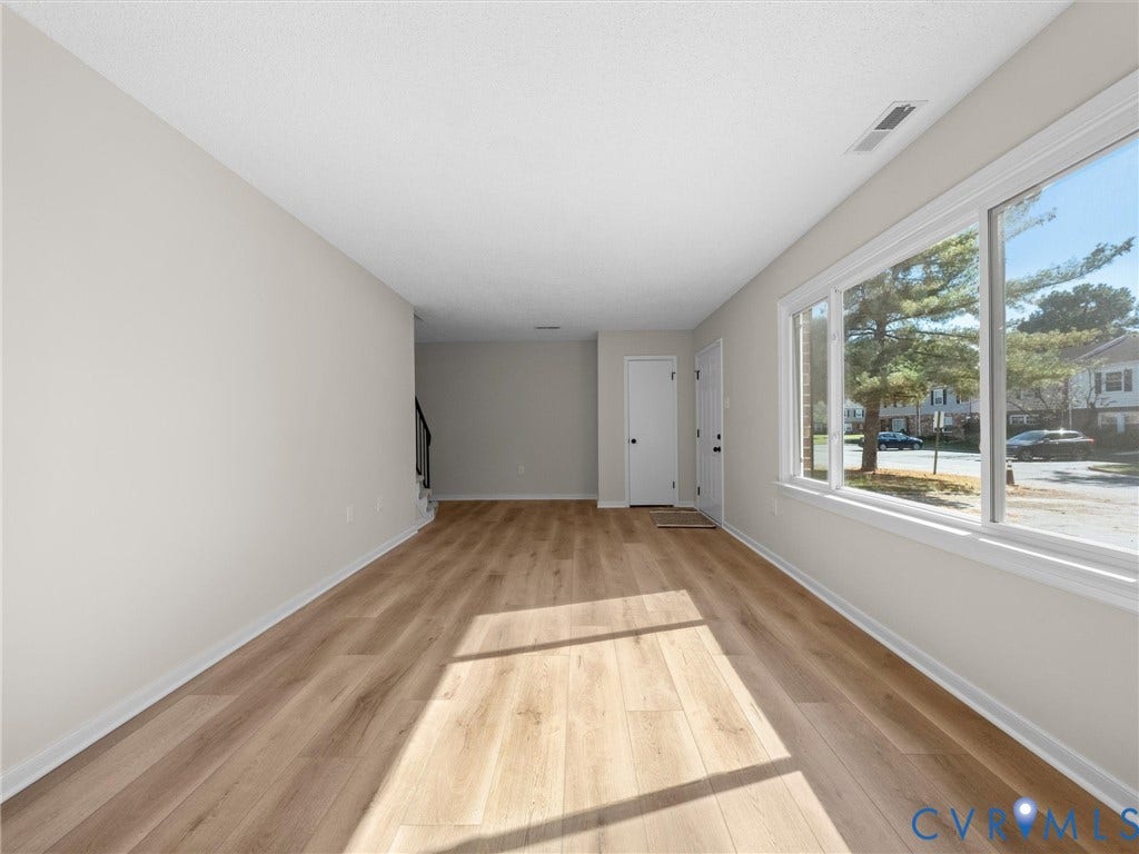 406 Alamosa Drive, Henrico, VA 23075 Neutral-toned interior space featuring wood-finish flooring, white walls, and a large horizontal window