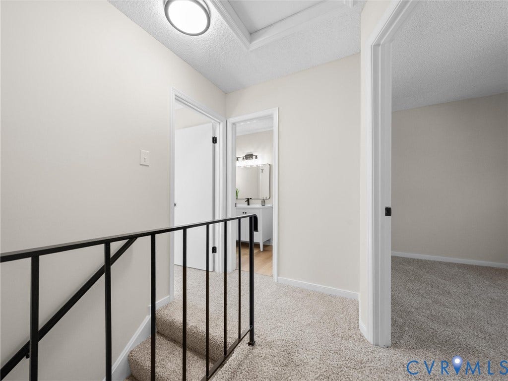 406 Alamosa Drive, Henrico, VA 23075 Hallway featuring neutral wall tones, wall-to-wall carpeting, metal stair railing, and multiple interior doorways
