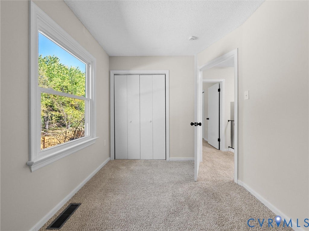 406 Alamosa Drive, Henrico, VA 23075 Neutral-toned interior space featuring neutral wall-to-wall carpeting, a single-hung window with white trim, and a double-door closet with white folding panels