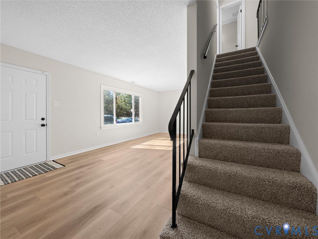 406 Alamosa Drive, Henrico, VA 23075 Entryway featuring wood-finish flooring, a multi-pane window, and a staircase with carpeted treads and a metal handrail