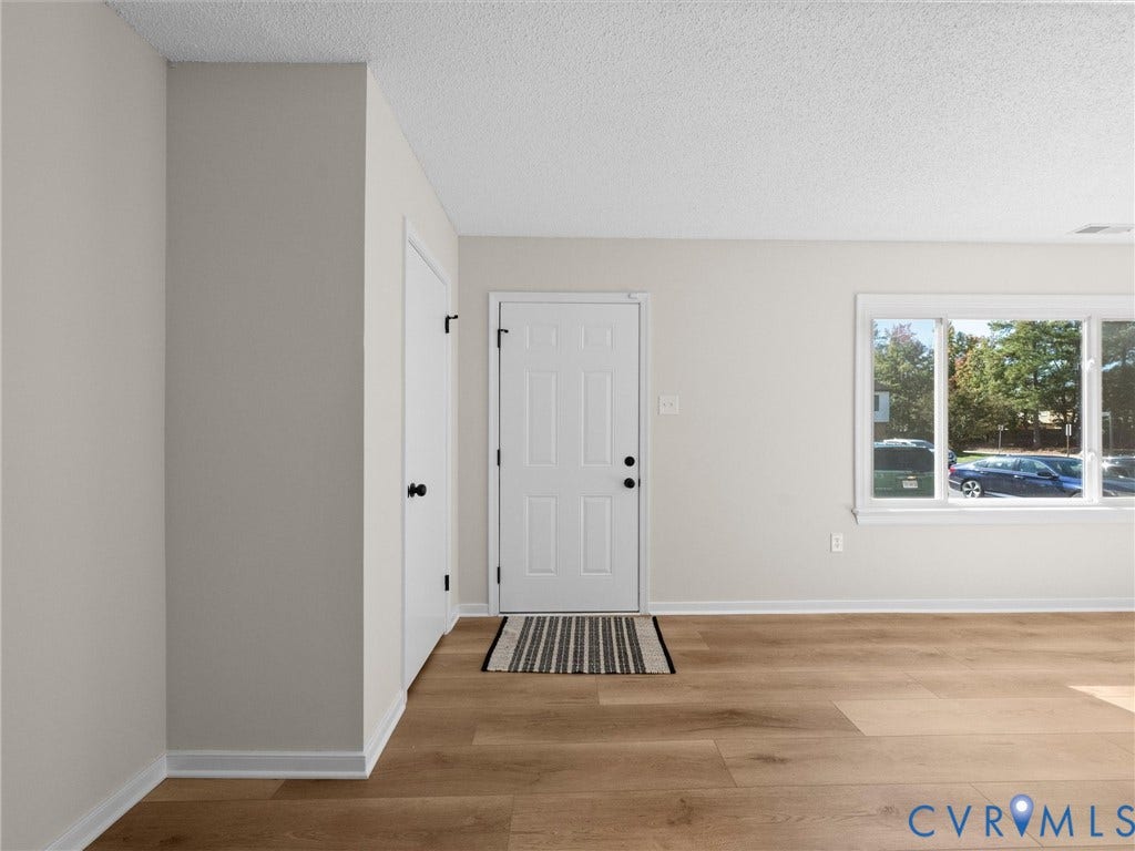406 Alamosa Drive, Henrico, VA 23075 Neutral-toned interior featuring wood-finish flooring, a six-panel entry door, and an expansive picture window