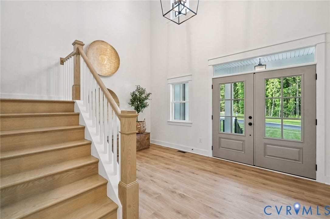 9156 Terroir Lane, The Viniterrta Villas, New Kent, VA 23124 Foyer featuring high ceilings, double entry doors with glass inserts, wood-finish flooring, staircase with wood handrails, and a geometric pendant light fixture