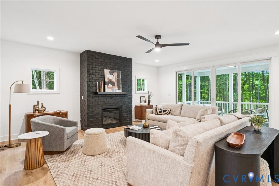 9156 Terroir Lane, The Viniterrta Villas, New Kent, VA 23124 Floor-to-ceiling painted brick fireplace, wood-finish flooring, recessed lighting, matte black ceiling fan, and multi-panel sliding glass doors