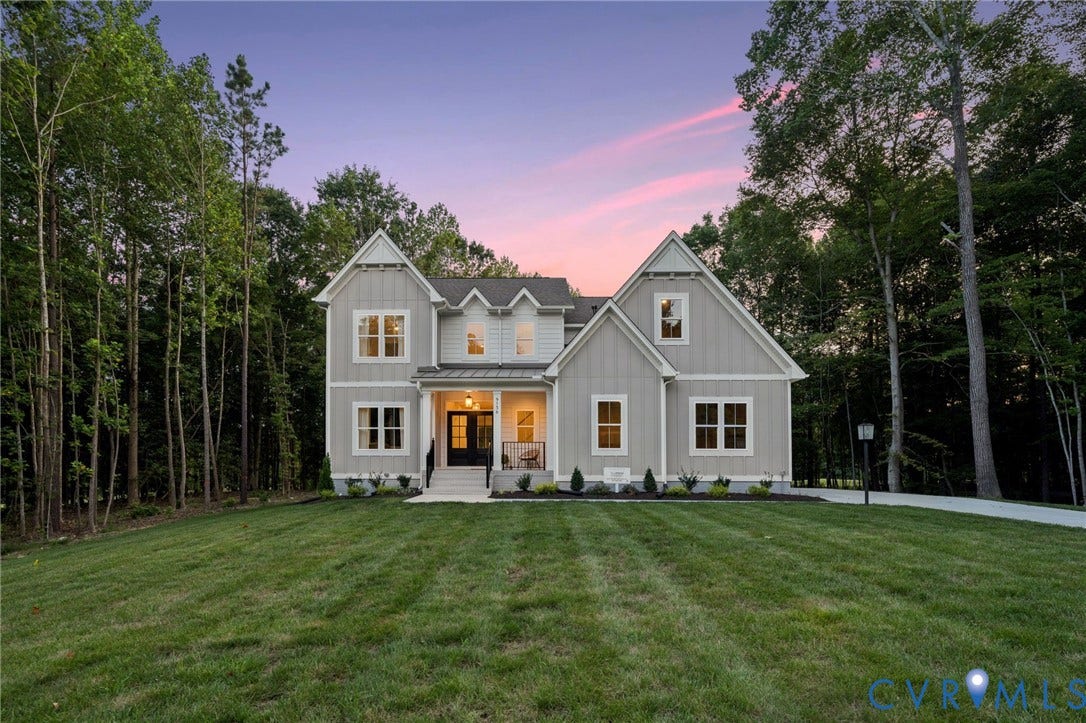 9156 Terroir Lane, The Viniterrta Villas, New Kent, VA 23124 Two-story exterior featuring light-toned vertical siding, a covered front entryway with metal roofing accents, multiple gables, and multi-pane windows