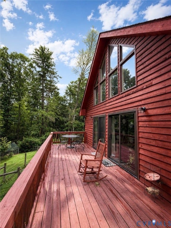 65 Cubbley Road, Hot Springs, VA 24445 Red wood-sided exterior featuring an expansive wrap-around deck, floor-to-ceiling glass sliding doors, and large triangular windows