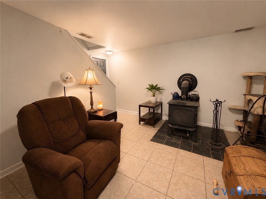 65 Cubbley Road, Hot Springs, VA 24445 Cast iron wood-burning stove set upon a dark tile hearth with ceramic tile flooring