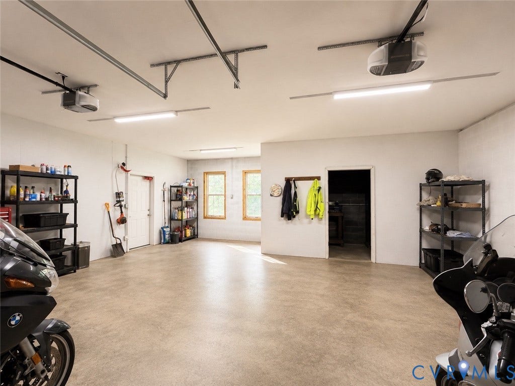 65 Cubbley Road, Hot Springs, VA 24445 Spacious multi-car garage featuring textured concrete flooring, dual automatic garage door openers, energy-efficient LED lighting, and double-pane windows