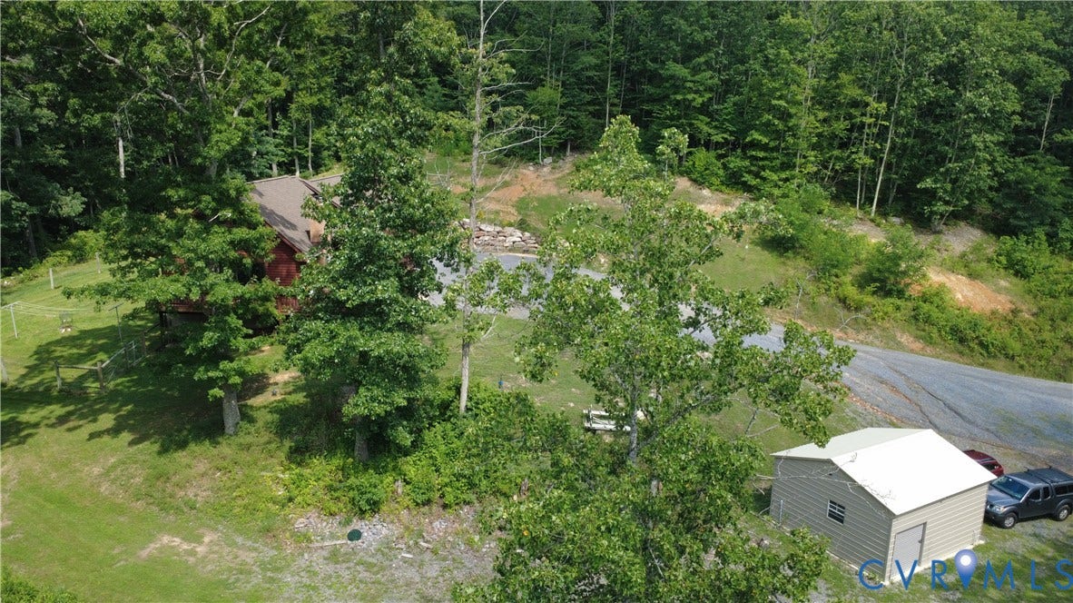 65 Cubbley Road, Hot Springs, VA 24445 Wooded parcel featuring a gravel driveway, detached storage structure, and expansive grass acreage