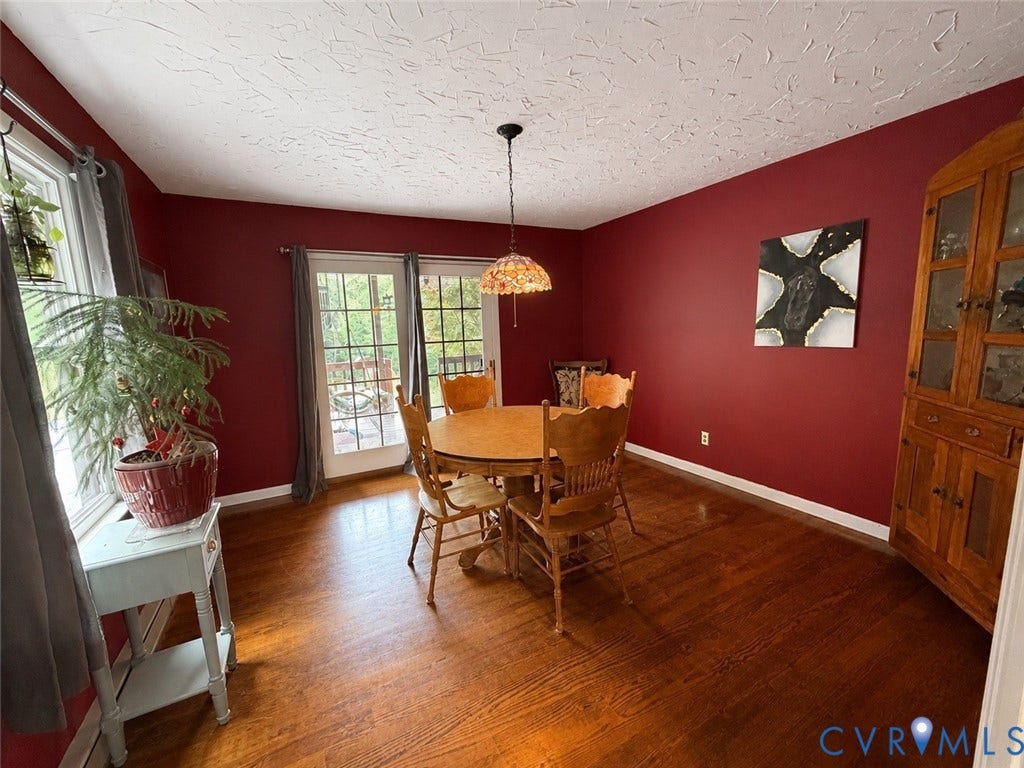 65 Cubbley Road, Hot Springs, VA 24445 Dining area featuring wood-finish flooring, glass-paned double doors, a built-in wood china cabinet, and a multi-faceted stained-glass pendant light