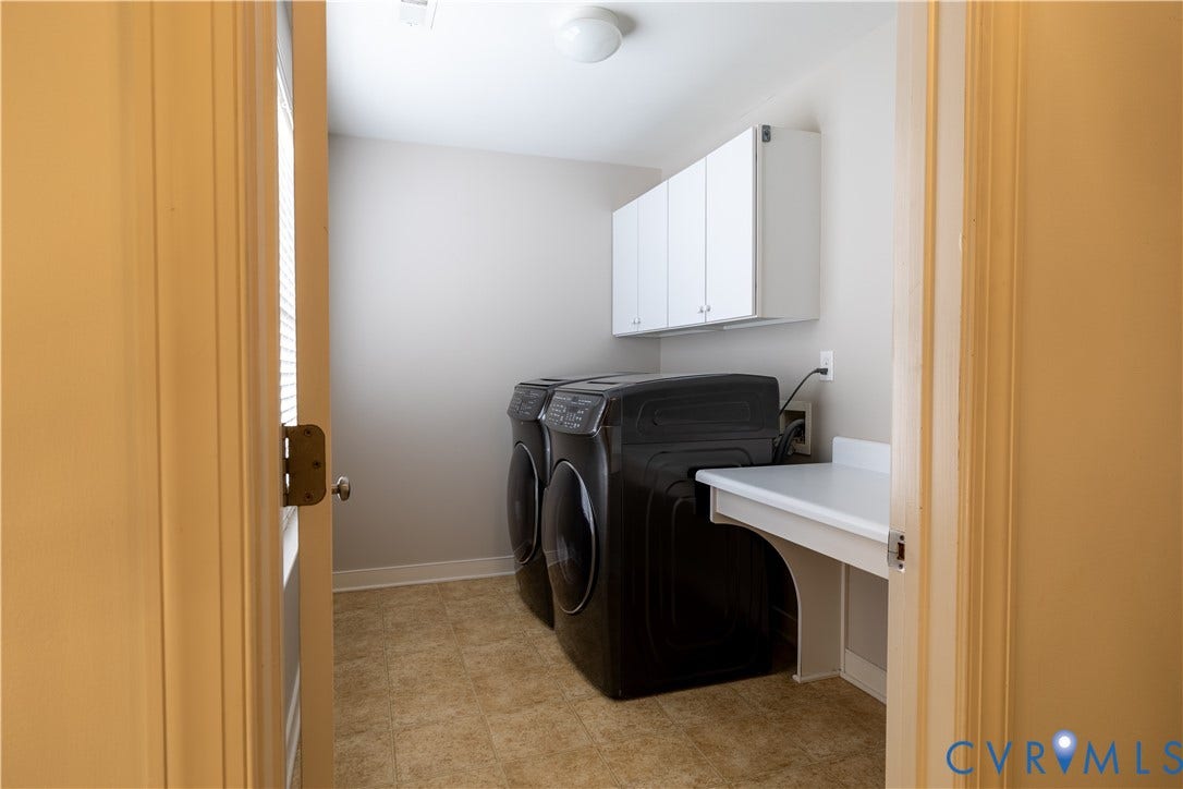 Utility room featuring wall-mounted white cabinetry, a built-in white laminate countertop, and vinyl tile flooring