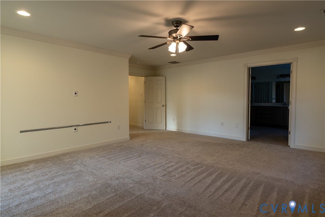 Spacious interior featuring wall-to-wall carpeting, recessed lighting, a ceiling fan with integrated light fixture, and two interior doors