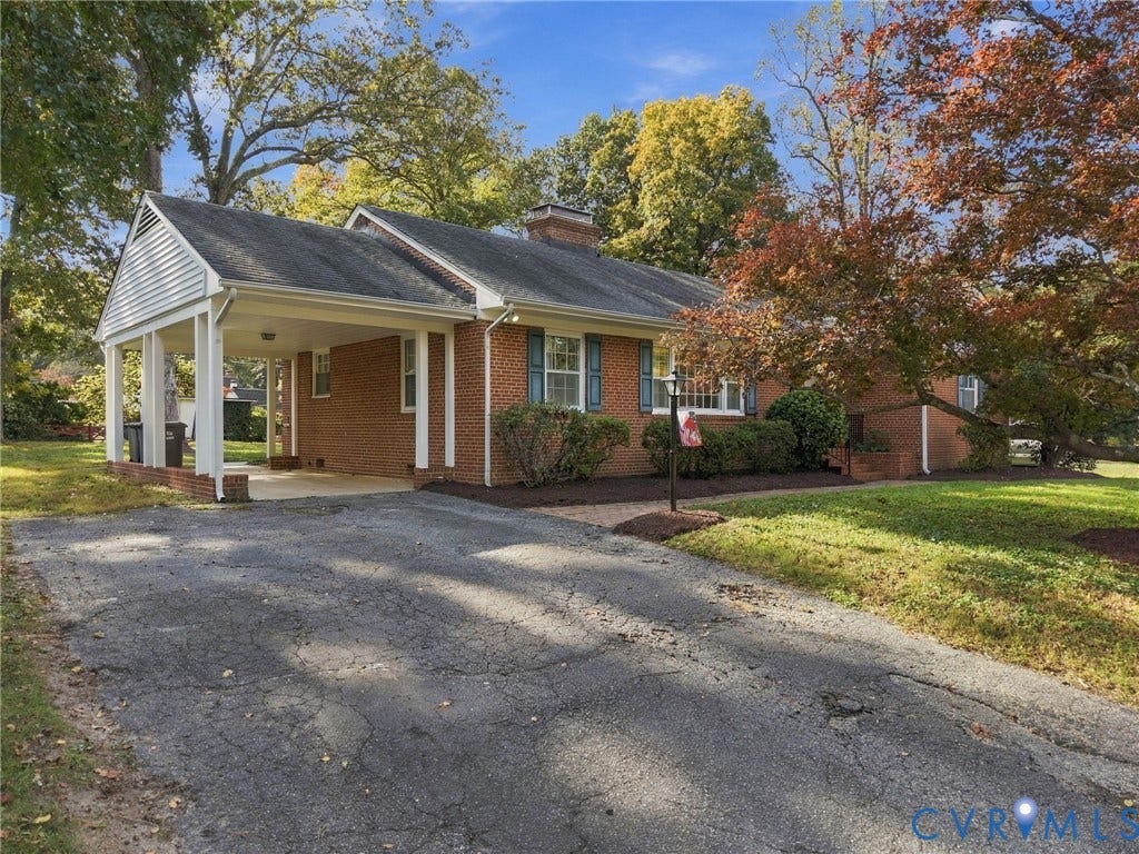 7506 N Pinehill Drive, Henrico, VA 23228 Brick exterior featuring an attached carport, asphalt driveway, chimney, and multi-pane windows with shutters