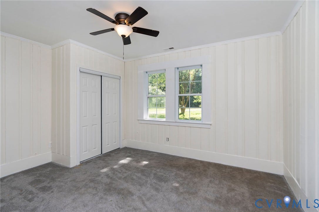 14043 Jefferson Highway, Louisa, VA 23024 Room featuring vertical paneled walls, neutral carpet, double-hung windows, and a ceiling-mounted light fixture with integrated fan