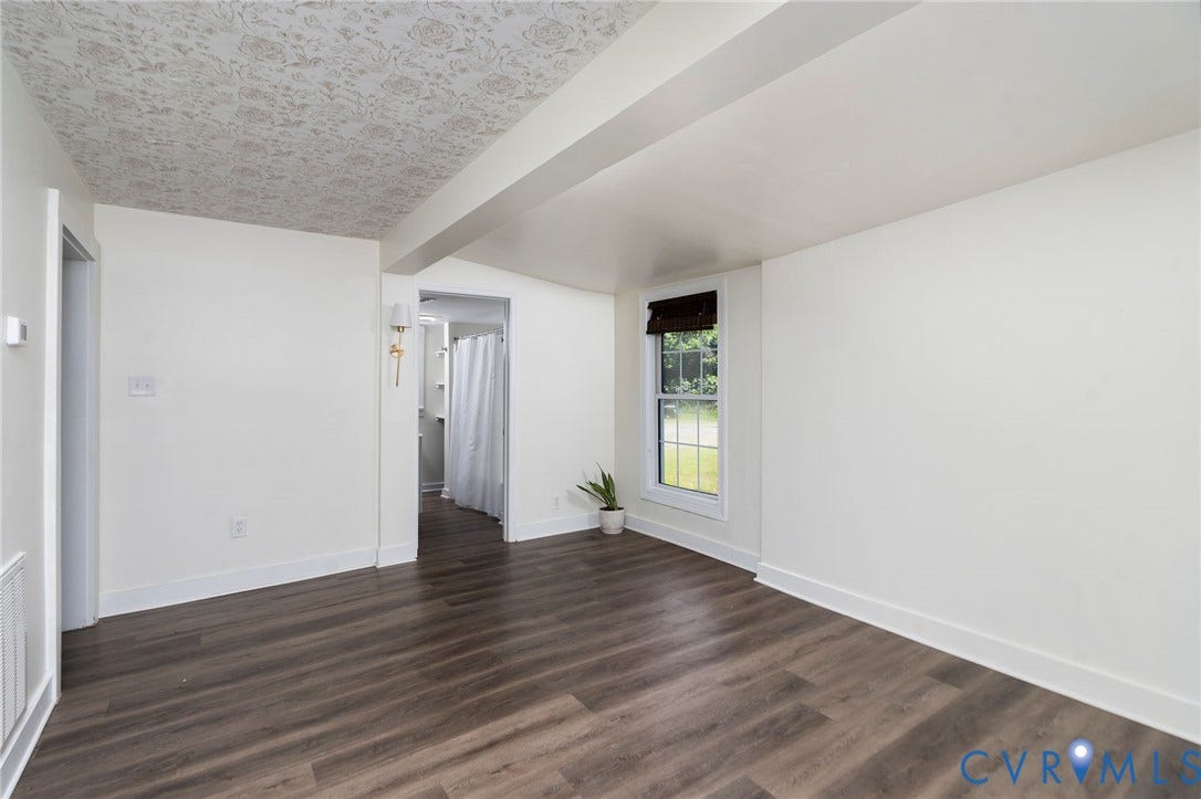14043 Jefferson Highway, Louisa, VA 23024 Interior space featuring wood-finish flooring, patterned ceiling detailing, a single-hung window with a roller shade, and wall-mounted brass lighting