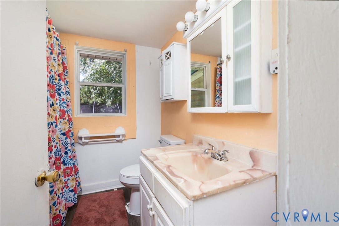14043 Jefferson Highway, Louisa, VA 23024 Bathroom featuring a white vanity cabinet with an integrated sink and countertop, a wall-mounted medicine cabinet with integrated lighting, and a single-pane window