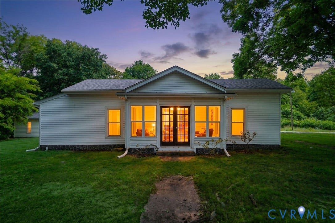 14043 Jefferson Highway, Louisa, VA 23024 Exterior facade featuring light-colored horizontal siding, a gabled roofline, prominent multi-pane glass French doors, and expansive surrounding lawn